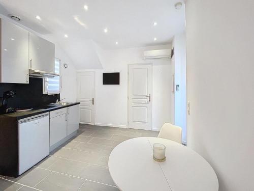 une cuisine avec une table blanche et un comptoir blanc dans l'établissement Studio - air conditioning - Juan-les-Pins city center, à Antibes