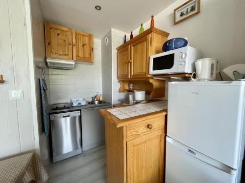 une petite cuisine avec un réfrigérateur et un micro-ondes dans l'établissement Les Myrtilles, à Arette