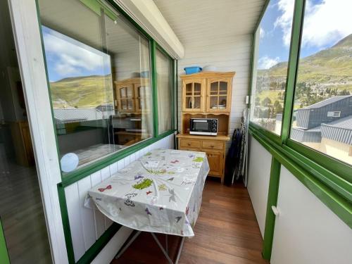 une petite table dans une pièce avec une fenêtre dans l'établissement Les Myrtilles, à Arette