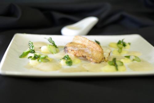 a plate of food with a piece of fish on pasta at Logis Hotel Restaurant Au Boeuf Rouge in Niederschaeffolsheim