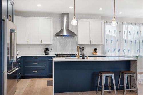 a blue kitchen with white cabinets and a blue island at New House with Chef's Kitchen and Spa-like Suite in Seattle
