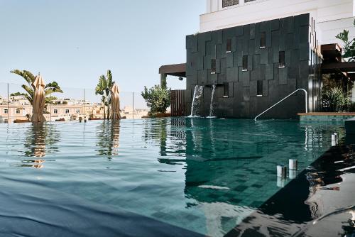 basen z fontanną wodną obok budynku w obiekcie Thompson Madrid, by Hyatt w Madrycie