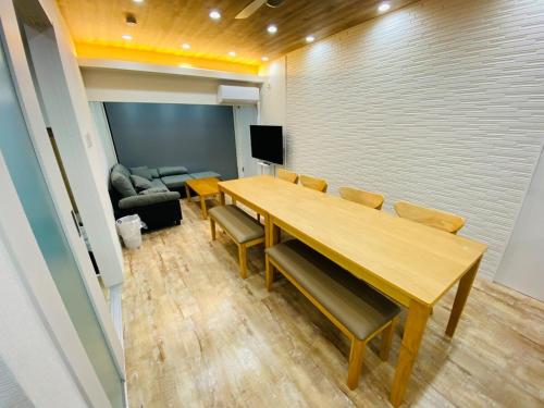 a conference room with a table and chairs and a couch at 時間を忘れる貸別荘イーストブルー in Hatsukaichi