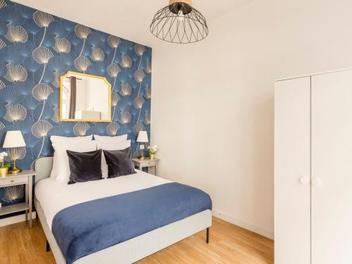 une chambre avec un lit avec un mur bleu dans l'établissement Merveil - Family Suite - Louvre - Sentier II, à Paris