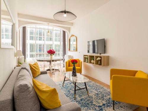 un salon avec un canapé et une table dans l'établissement Merveil - Family Suite - Louvre - Sentier II, à Paris