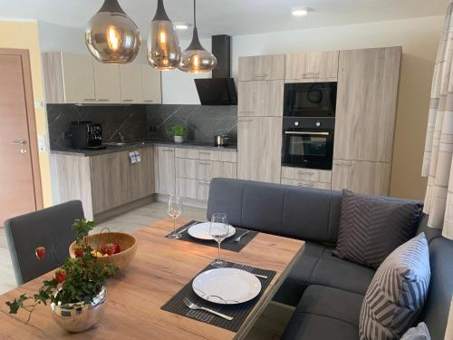a kitchen with a wooden table with plates and wine glasses at App. Marlos in Leisach