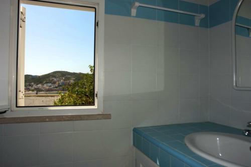 baño con ventana y lavabo en Turistcasa - La Parata 41, en Ponza