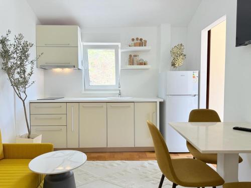 a kitchen with a white refrigerator and a table at Studio Petrovac in Kravlja