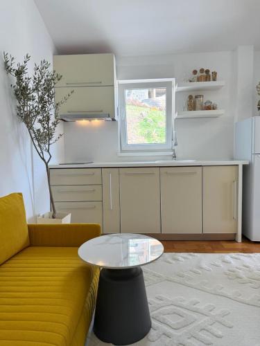 a living room with a yellow couch and a table at Studio Petrovac in Kravlja