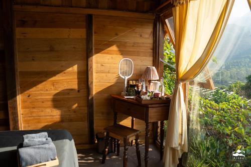 a bedroom with a desk in a room with a window at Xieng Retreat in Hanoi