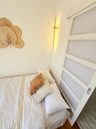 a bedroom with a bed with white sheets and pillows at Studio Petrovac in Kravlja