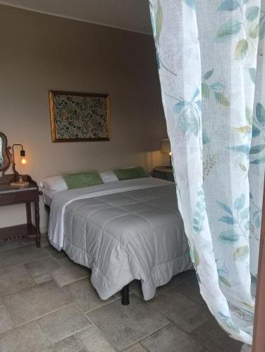 a bedroom with a bed and a curtain at Il Borgo B&B in Castellinaldo