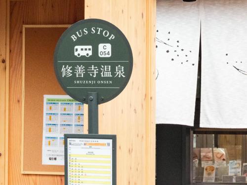 a bus stop sign in front of a building at Shuzenji Onsen Hotel Takitei in Izu
