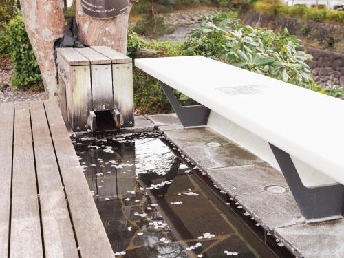 a white bench sitting on top of a body of water at Shuzenji Onsen Hotel Takitei in Izu