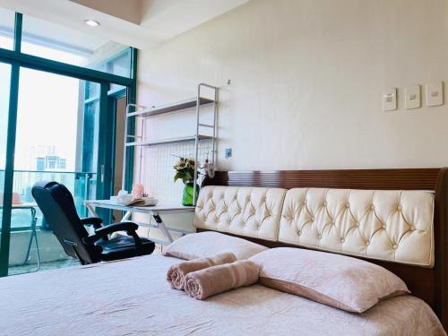 a bedroom with a bed with a chair and a desk at Seaview unit in Manila