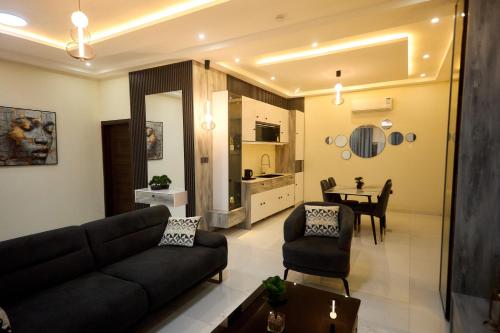 a living room with a couch and a dining room at Abram Hills Hotel Ltd in Koforidua