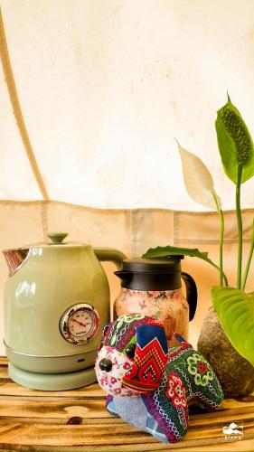 a table with a vase and a clock and a plant at Xieng Retreat in Hanoi