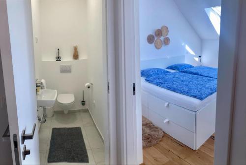 a small bathroom with a blue bed and a toilet at Sunny AP22 in Bovec