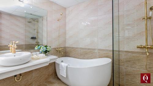 a bathroom with a tub and a sink and a shower at Splendid Secret Hotel in Hanoi