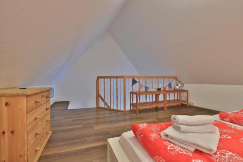 a bedroom with a bed and a dresser and a crib at Fischerhaus Whg Sonnenaufgang in Neukloster