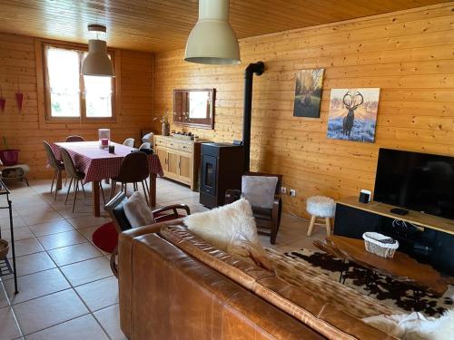 un salon avec un canapé et une table dans l'établissement Chalet de Laveline, à Laveline