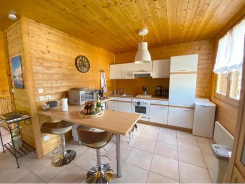 une cuisine avec une table et des chaises dans une pièce dans l'établissement Chalet de Laveline, à Laveline
