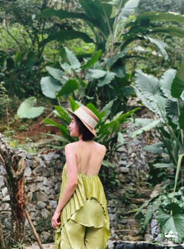 a woman wearing a yellow dress and a hat at Xieng Retreat in Hanoi