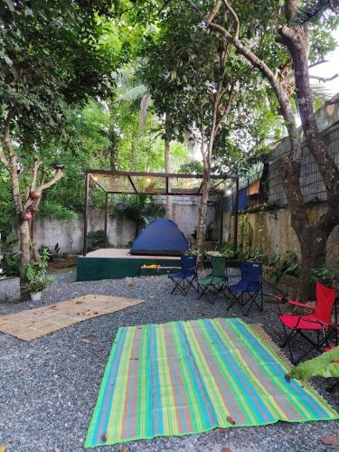 a colorful rug in a backyard with a tent and chairs at Sotera and Paz Forestville in Silang