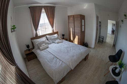 a bedroom with a large bed and a window at Bárka Vendégház Aggtelek in Aggtelek