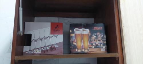a book shelf with two bottles of beer and a pair of baseball bats at Serene BnB - Apt 08 Makongo after Mlimani City in Dar es Salaam