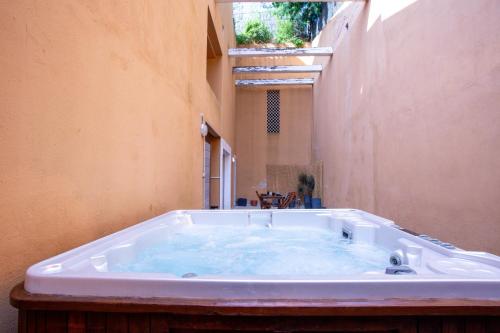 une grande baignoire dans l'angle d'un bâtiment dans l'établissement Iero - Avec Jacuzzi à 4min de la Plage, à Bormes-les-Mimosas