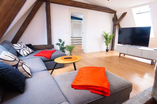 a living room with a couch and a flat screen tv at BetterBeds City - Apartments - Zentral - Smart TV - Küche - WLAN in Brandenburg an der Havel
