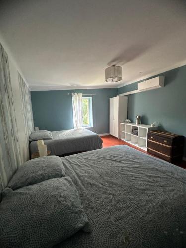 - une chambre bleue avec 2 lits et une fenêtre dans l'établissement Ancienne Maison de Campagne, à Grans