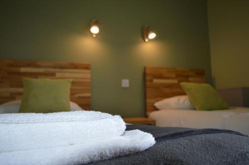 a room with two beds with white towels on the bed at The Valley Hotel, Anglesey in Valley