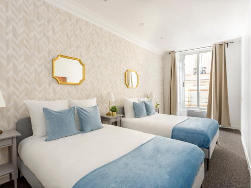 une chambre d'hôtel avec deux lits et un miroir dans l'établissement Merveil - Family Suite - Marais - Saint Denis II, à Paris