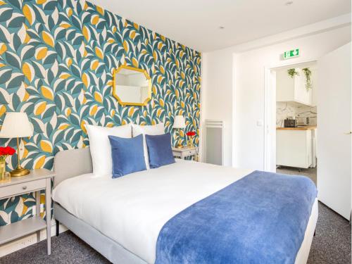 - une chambre avec un lit et un mur bleu et jaune dans l'établissement Merveil - Family Suite - Marais - Saint Denis II, à Paris