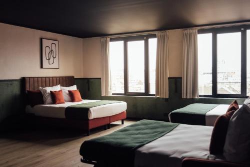 a hotel room with two beds and windows at Getaway Studios Liège in Liège