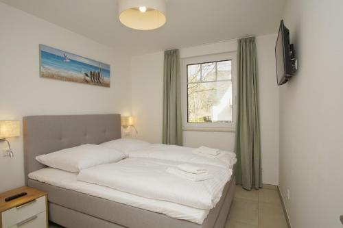 En eller flere senge i et værelse på Rex Rugia FeWo12-1 mit Schwimmbad und Saunanutzung im AHOI-Erlebnisbad Sellin