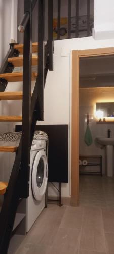 a washing machine in a laundry room with a staircase at La Casita de Cullera in Cullera