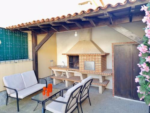 a patio with a table and chairs and a fireplace at Mbird Rosario Family House in Cascais