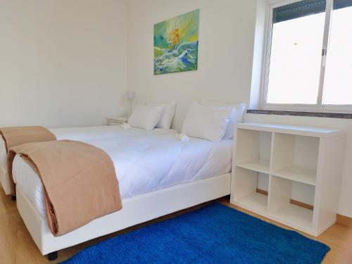 a bedroom with a white bed and a window at Mbird Rosario Family House in Cascais
