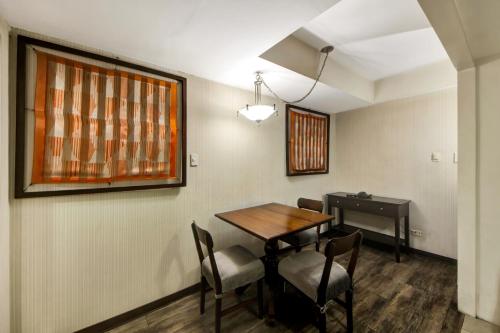 a dining room with a table and chairs and a desk at CEO Flats in Manila