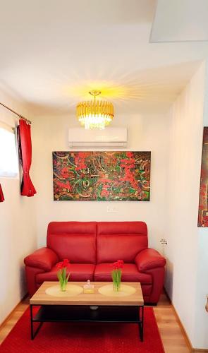 a living room with a red couch and a table at Tinyhouses am Neusiedlersee in Fertőrákos