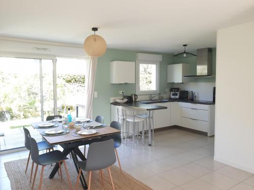 une cuisine et une salle à manger avec une table et des chaises dans l'établissement RIVAGE 2 - Maison en bord de mer Carnac-Plage - C33, à Carnac