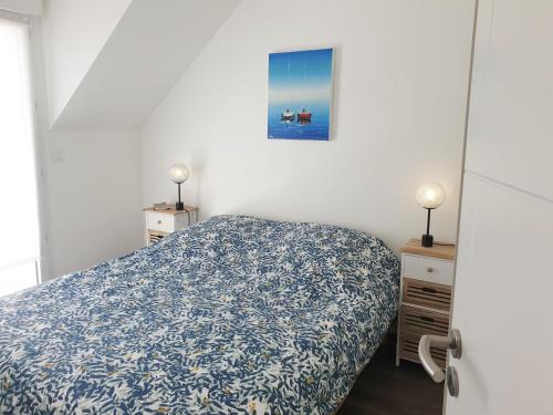 une chambre avec un lit avec un couvre-lit bleu et blanc dans l'établissement RIVAGE 2 - Maison en bord de mer Carnac-Plage - C33, à Carnac