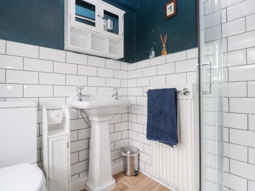 a white bathroom with a sink and a toilet at Pentira in Helston