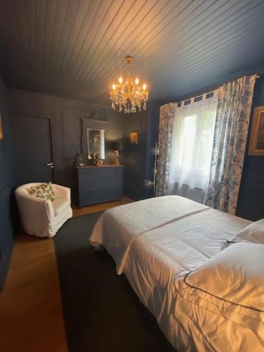 a bedroom with a bed and a chandelier at La Bastide in Rosières