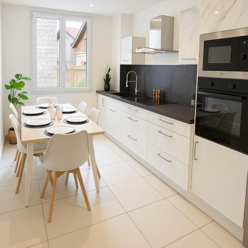une cuisine blanche avec une table et des chaises dans l'établissement Charmant appartement 3 grandes chambres au coeur de Nice au calme absolu, à Nice