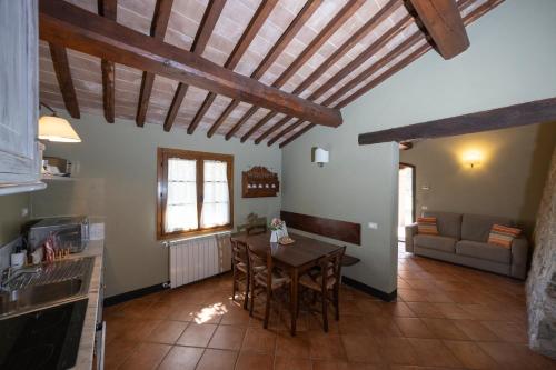 a kitchen and living room with a table and a couch at Borgo dé Brandi in Monteriggioni