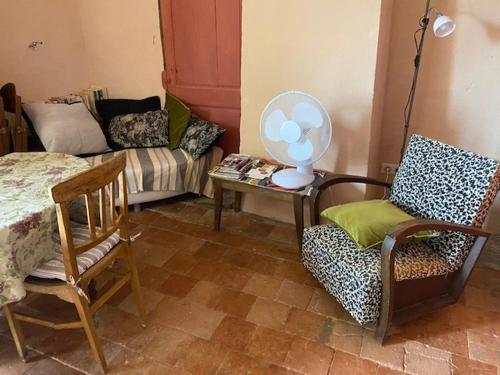 - un salon avec un lit, une chaise et une table dans l'établissement Tour 17e s pour 4, panoramique Cévennes, à Mars